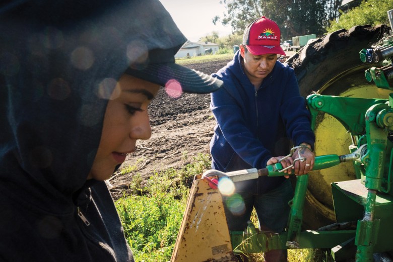 Maria Narez, right, and her wife, Esme, prepare their tractor for field work.